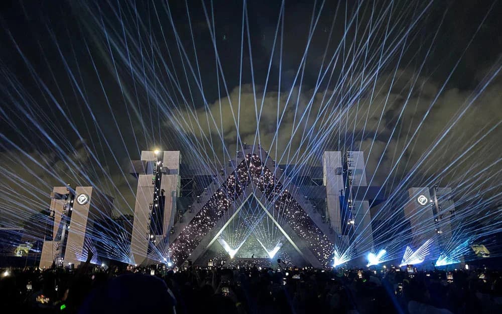 Blue laser fans crossing the triangular Barbarella stage above the audience